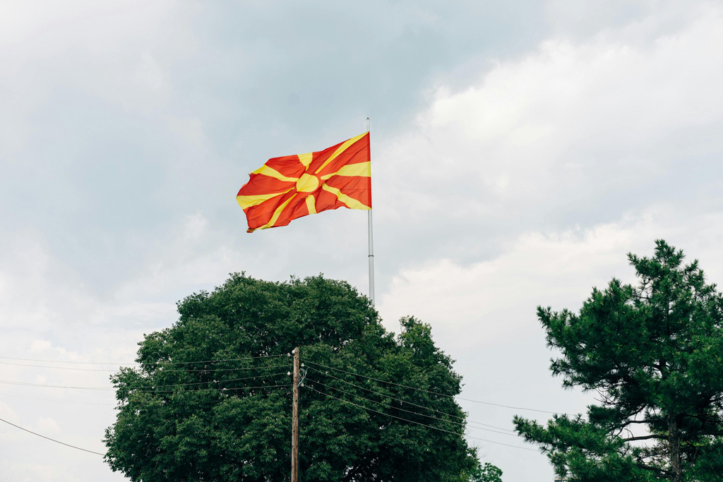 Nationalflagge Nordmazedonien, © Bild https://www.pexels.com/de-de/foto/baume-stolz-nationalflagge-bewolkter-himmel-2862157/